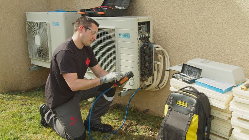 Contrat entretien chaudière, pompe à chaleur : technicien Abitibi en train d'assurer la maintenance d'une pompe à chaleur
